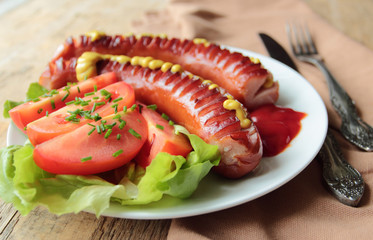 Plate with grilled sausages with fresh tomatoes