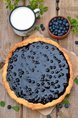 Blueberry pie, cup of milk on wooden table