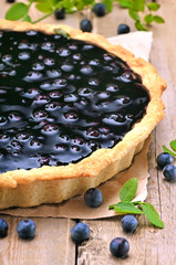 Blueberry pie and fresh berries on wooden table