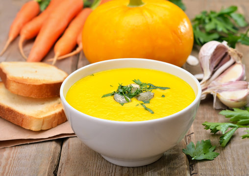 Pumpkin cream soup on wooden table