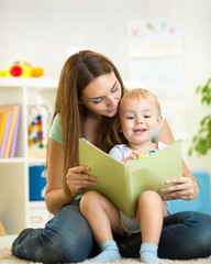 mom and kid boy read a book at home