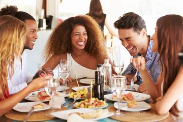 Selbstklebende Fototapete Restaurant Gruppe junger Freunde, die eine Mahlzeit im Restaurant im Freien genießen?