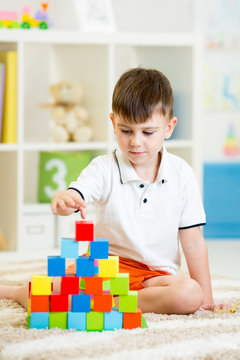 Child playing with building blocks at home.
