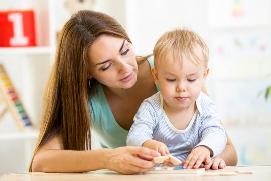 child boy and mother play toy at home