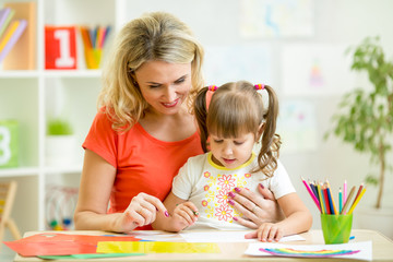 mother and her kid drawing with pencils together © Oksana Kuzmina
