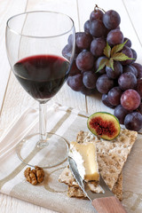 French soft cheese Brie, fruit and glass of red wine
