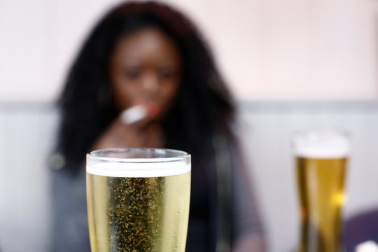 African Woman Drinking Beer In A Pub