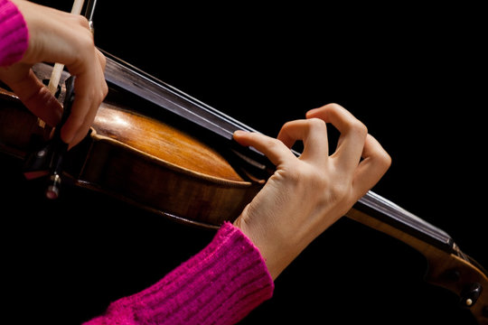 Girl's hand on the strings of a violin