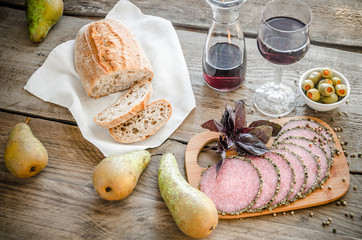 Slices of italian salami with pears and wine