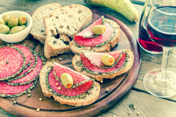 Slices of italian salami with pears and wine