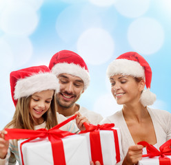 happy family in santa helper hats with gift boxes