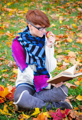 Beautiful girl with book in the autumn park