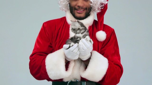 Santa Claus giving a kitten as a gift for Christmas