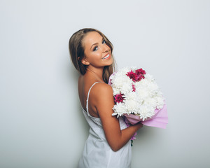 Young woman with bouquet of flowers over white background
