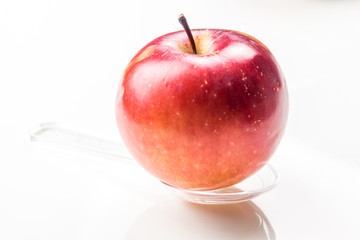 red apple on translucent medicine spoon on the table