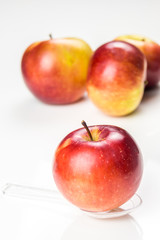 red apple on translucent medicine spoon on the table