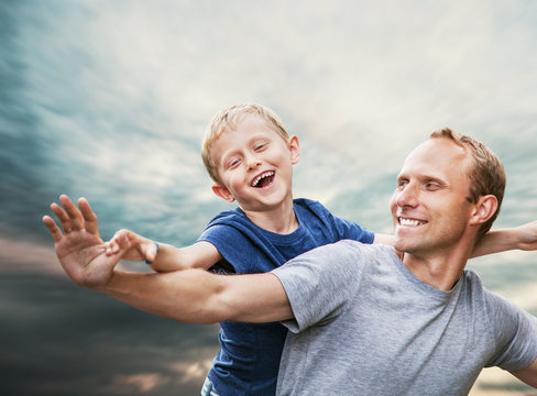 Happy smiling son and  father portrait over blue sky