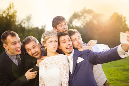 Bride with groom and his friends taking selfie