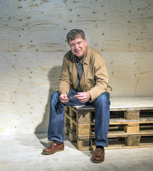 handsome man sitting on palettes
