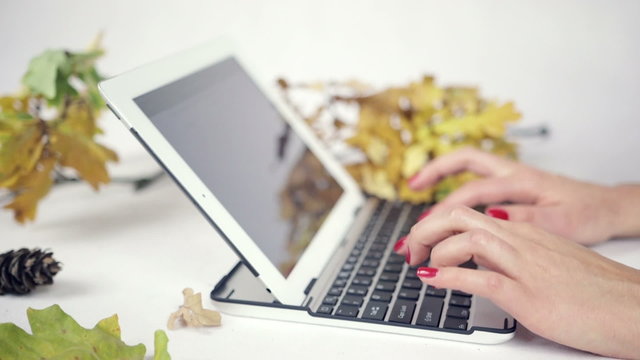 Close up on woman's hands typing on her laptop in bright studio