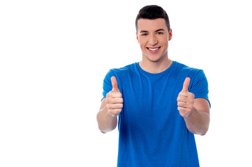 Young smiling man showing thumbs up