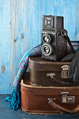 Retro camera and old suitcases on a blue wooden background. - 71518011