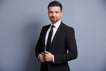 man adjusts his suit clothes