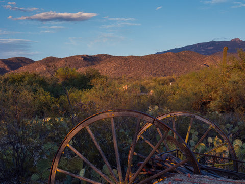 Rusted carriage weels in Arizona desert at sunset