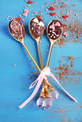 Spoons with tasty chocolate for party on old blue wooden table