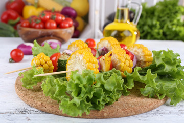 Sliced vegetables on picks on board on table close-up