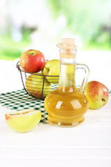 Apple cider vinegar in glass bottle and ripe fresh apples,
