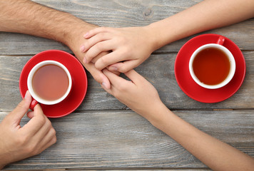 Loving couple with hot drinks on table