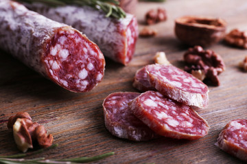 French salami and walnuts on wooden background