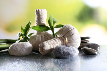 Spa composition with herbal massage bags, candle and bamboo