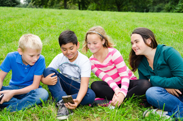 Fototapeta premium kinder schauen auf ein handy