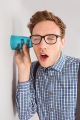 Geeky businessman eavesdropping with cup