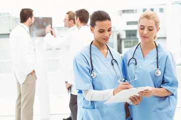 Two female surgeons looking at reports