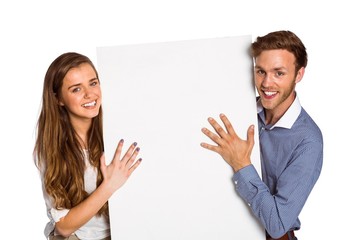 Happy young couple with blank board