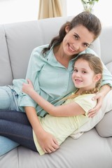 Cute mother and daughter on the couch