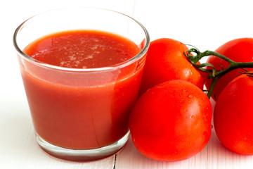 Tomato juice in glass and tomatoes