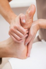 Pedicurist massaging customers foot