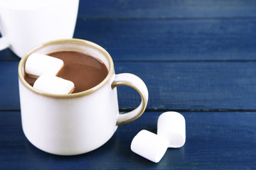 Hot chocolate with marshmallows in mug, on wooden background