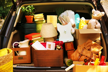 Moving boxes and suitcases in trunk of car, outdoors