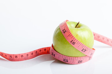 Measuring tape with green apple