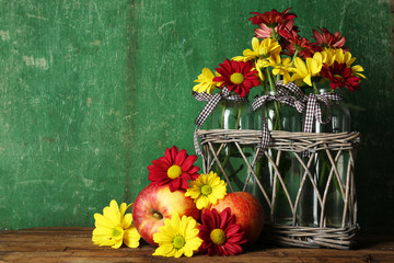 Fototapeta premium Beautiful chrysanthemum in vases with apples