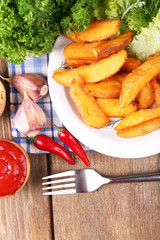 Homemade fried potato on plate on wooden background