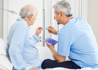Fototapeta premium Caretaker Guiding Prescription To Senior Man