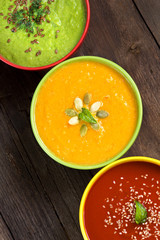 Three fresh soups on a wooden table