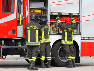 Naklejka premium firefighters working near the fire truck when handling an emerge