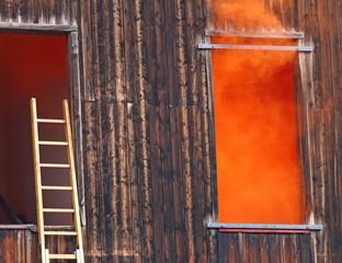 Orange smoke comes out of the window and a ladder of the fire ne